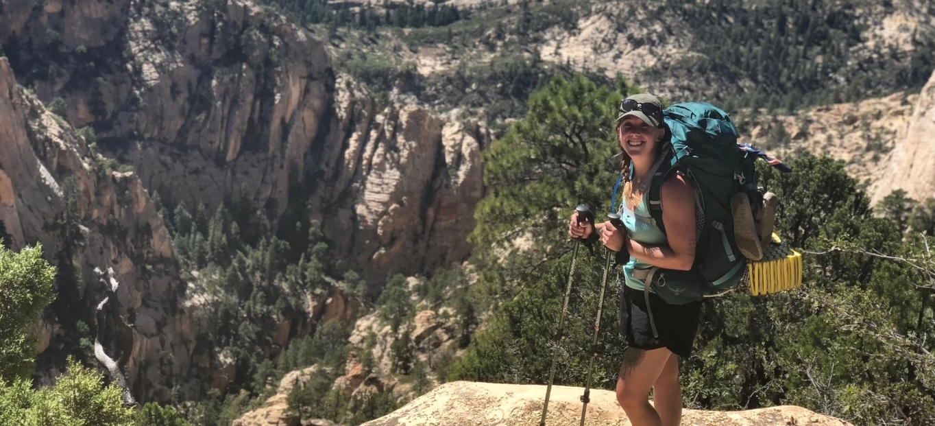 Miranda, a person living with obstructive sleep apnea, hiking with a backpack and trekking poles