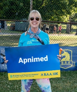 An Apnimed employee holding a sign for a 10K