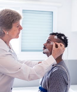 A doctor putting surface electrodes on a patient