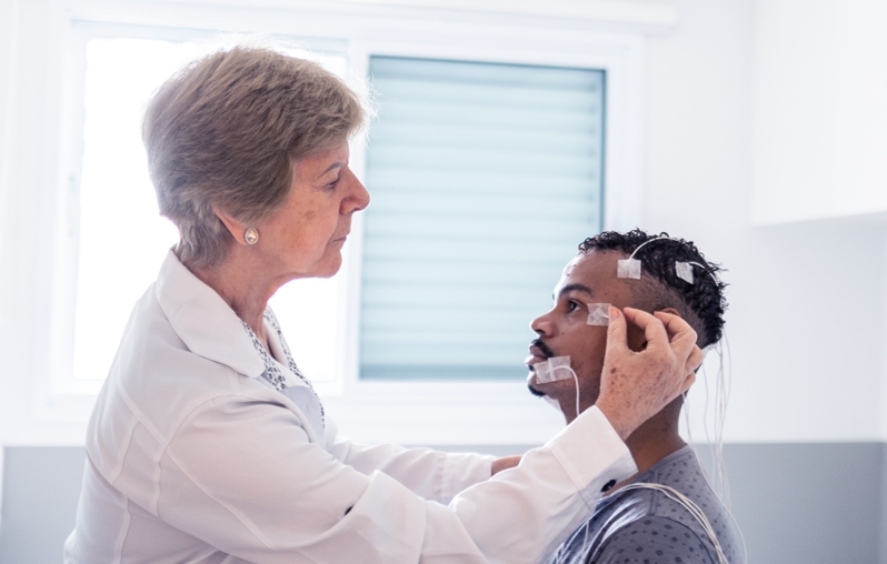 A doctor putting surface electrodes on a patient