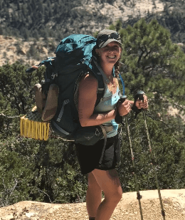 Miranda, a person living with obstructive sleep apnea, hiking with a backpack and trekking poles