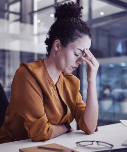 A woman with her eyes closed and her hand on her forehead